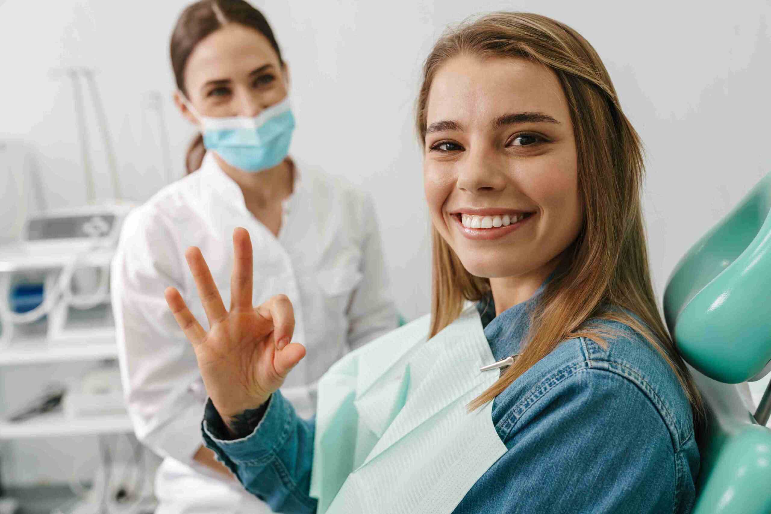 Smiling patient giving an OK sign after a dental appointment.
